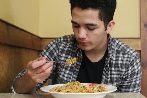 Senior Andres Munguia eats rice and chicken at Happy Family. 