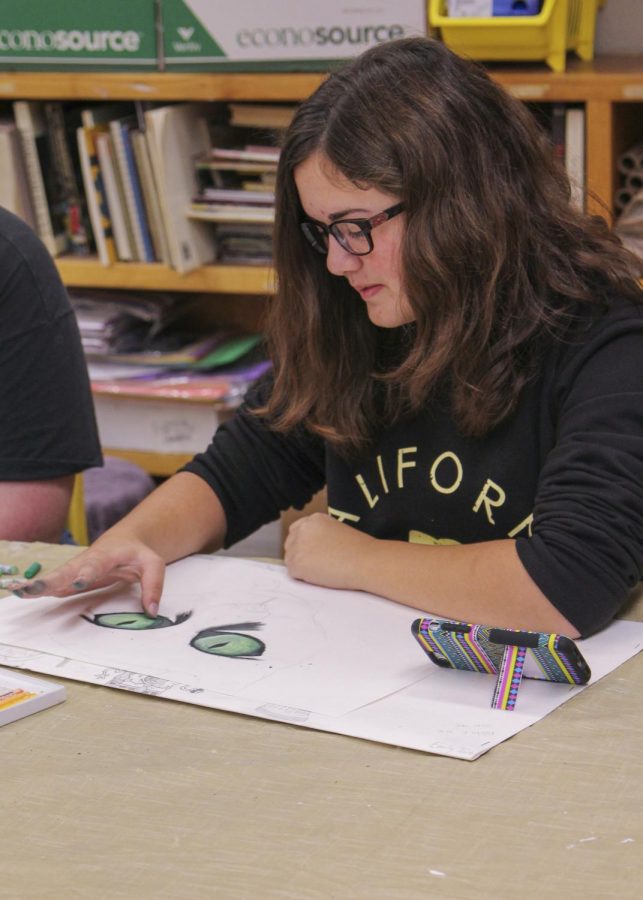 Freshman Emily Tarter, an art club member, adds the finishing touches to her drawing. 