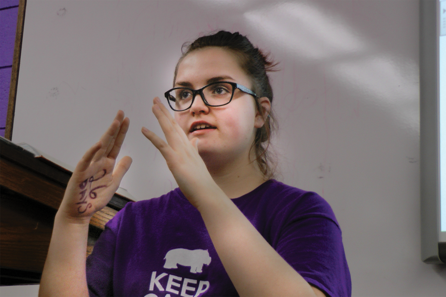 Freshman Emily Wachter teaches a word from American Sign Language (ASL) to the ASL Club during heir meeting last Wednesday after school. "I want to show other people how amazing sign language is," Wachter said. "I think that it’s so important that we learn ASL because [the deaf] don’t have anywhere to go. This is their place and we’re treating them like it isn’t."