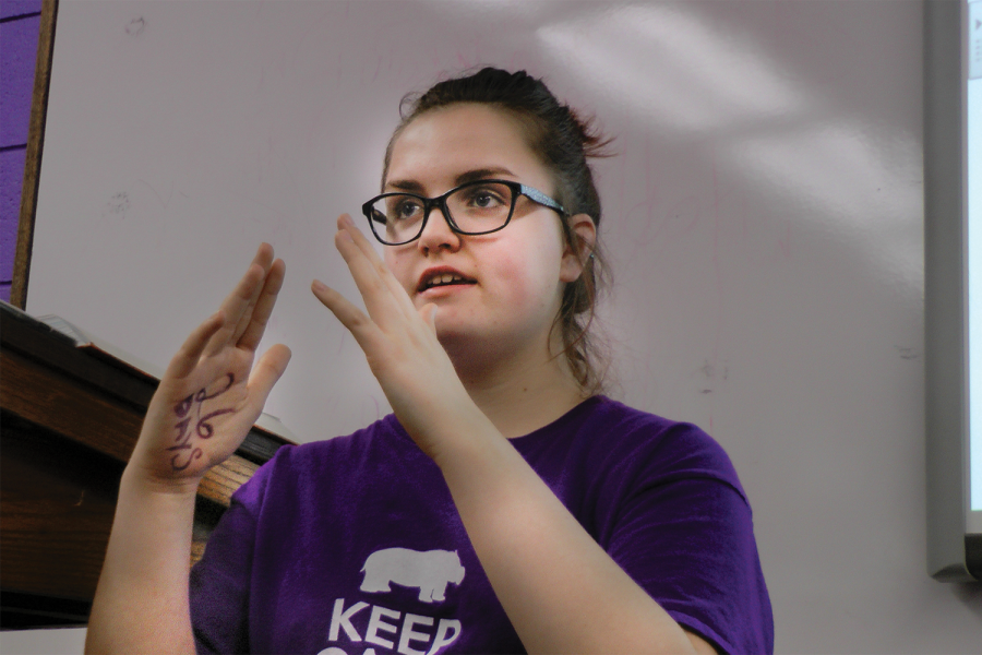 Freshman Emily Wachter teaches a word from American Sign Language (ASL) to the ASL Club during heir meeting last Wednesday after school. I want to show other people how amazing sign language is, Wachter said. I think that it’s so important that we learn ASL because [the deaf] don’t have anywhere to go. This is their place and we’re treating them like it isn’t.