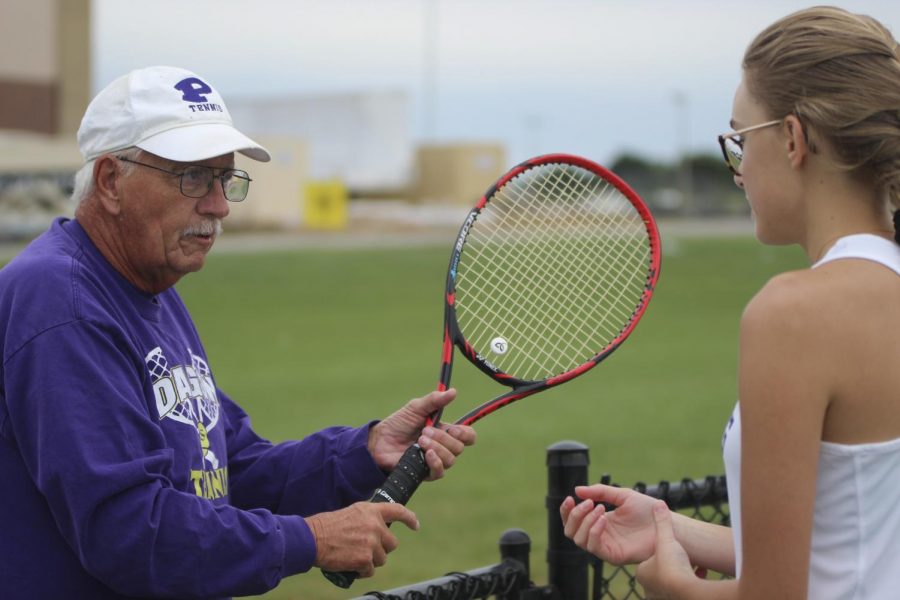 Head coach John Seal conferences with junior Sophia Shope after a match. Seal has coached Shope for her sophomore and junior years and also earned over 700 wins in his coaching career. "He's made me more confident in my ability to play and really encourages me to try my hardest ," Shope said. "[He] reminds me not to be hard on myself when I mess up."