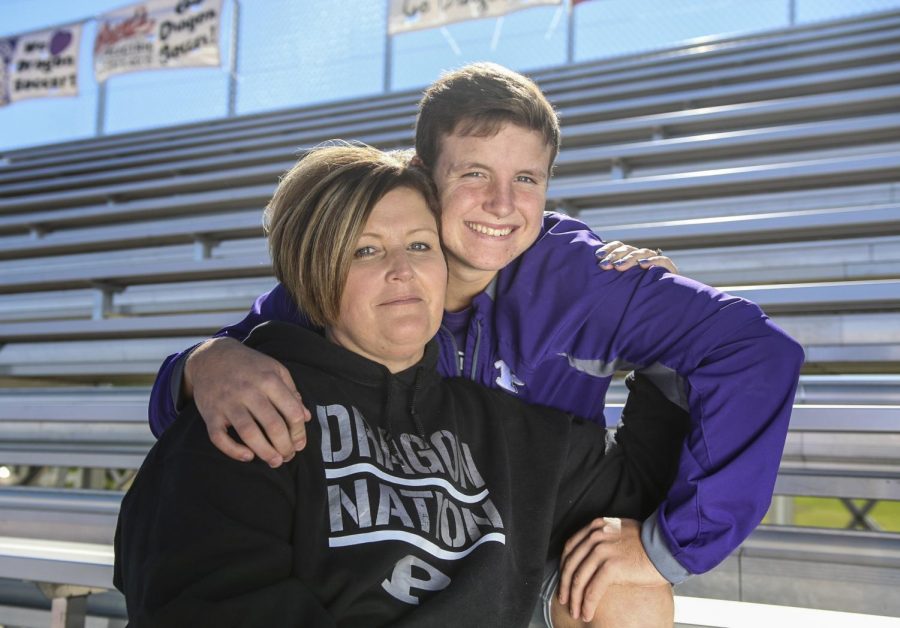 Sitting on the soccer bleachers, junior Caden Bressler embraces his mom, Trasie, who was diagnosed with breast cancer last spring. Caden plays varsity soccer and Trasie is a member of the soccer booster club. 
