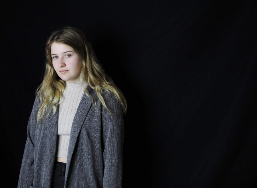 Scott models her pink sweater and gray blazer she thrifted at Goodwill. Photo by McKenna Hodges