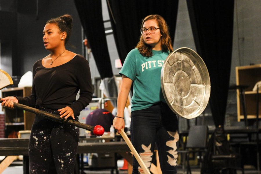 Seniors Mona Estes and Kylie Edson stand on stage and prepare to act out their fighting scene. 