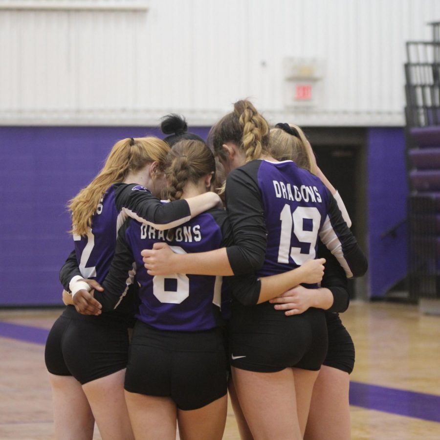 Members of the jv volleyball team huddle during a home tournament. The team finished the season 55-0.