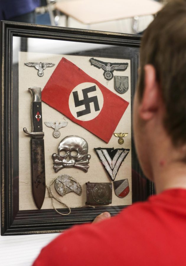 Junior Quentin Cole examines several artifacts brought in by Patrick Moss for his 7th hour American History class. Moss brought in primary sources to allow students a deeper immersion into their World War II lesson. "Getting to see those artifacts is really cool," Cole said. "He makes it really entertaining."