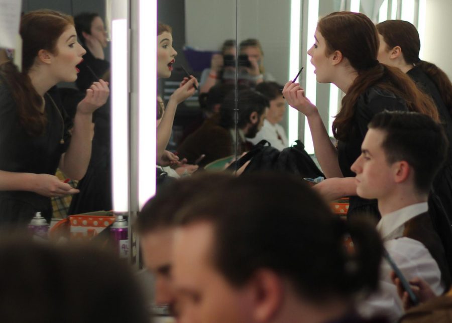 Junior Sophie Casper applies her makeup for her role as Yvette, the maid, in the Clue production. 