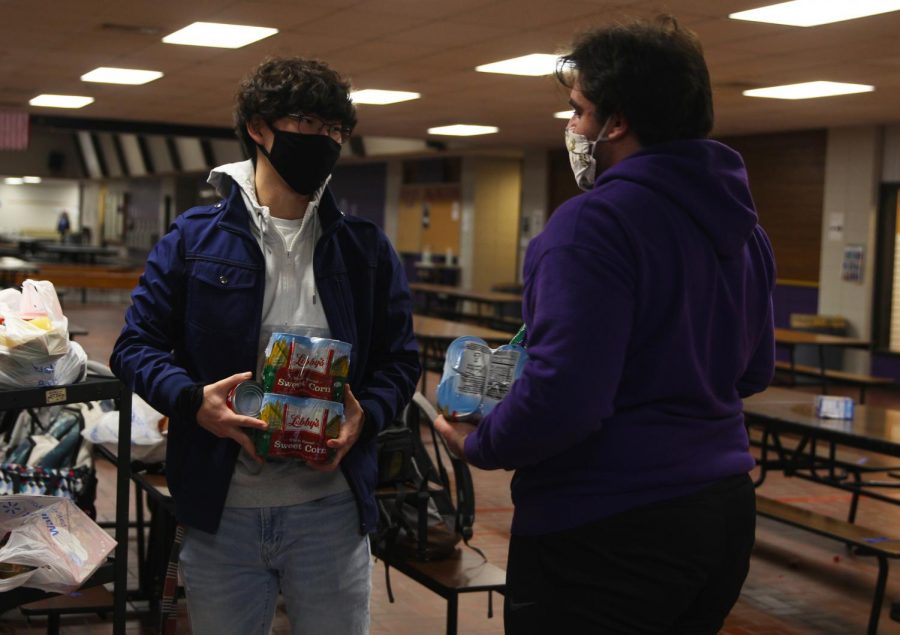 Seniors Joseph Lee (left) and Christopher Saman (right) discuss the donations National Honors Society made for a food drive hosted by the Culinary Dragons and Student Council.