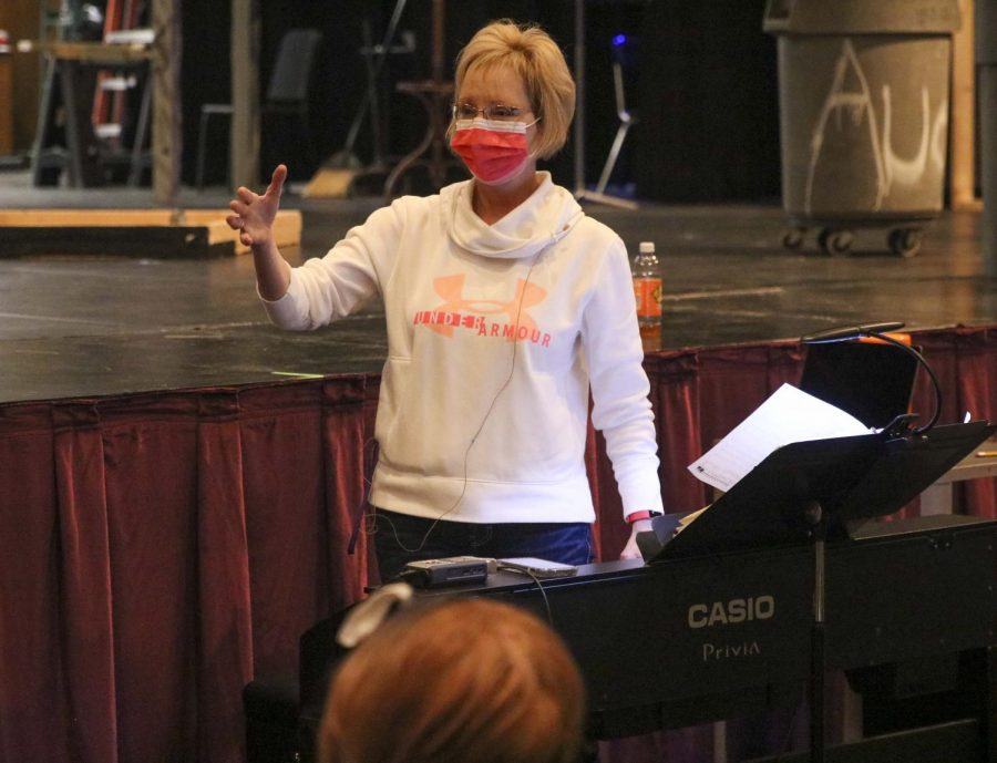 Choir director Susan Laushman conducts students in Encore while preparing contest submissions.