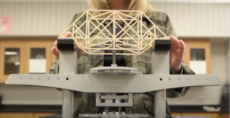 Sally Ricker demonstrates physics class project by building a bridge