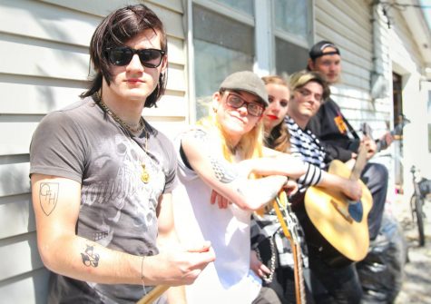 Members of the local band One Fret High drummer Will Donnivan, lead guitarist Gaelig, lead vocalist Ari St. Claire, rhythm guitarist Colton Stacy, and bass player Andrew Turner pose alongside their rehearsal location. 