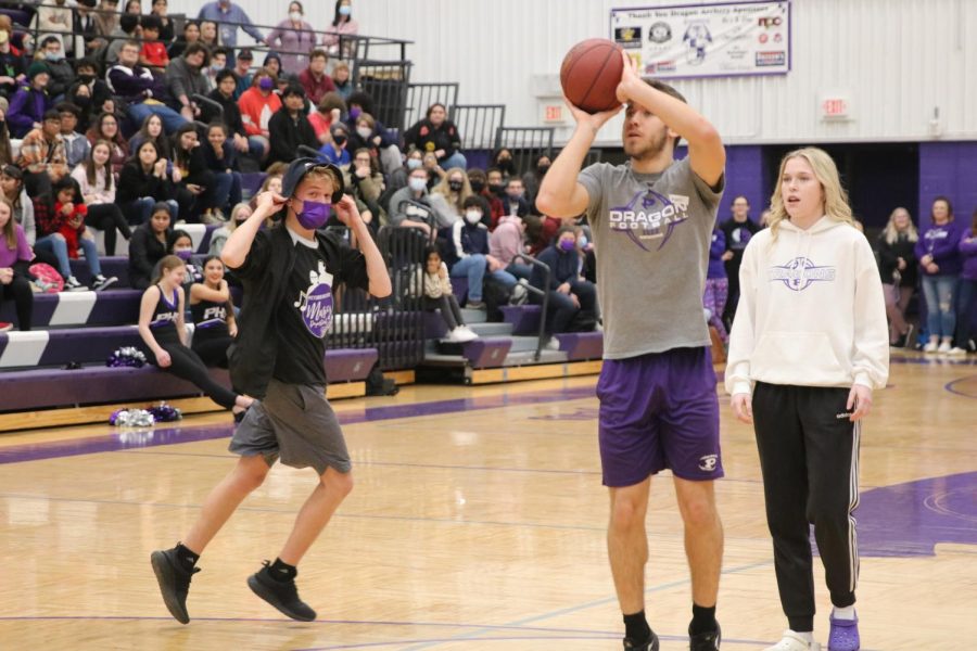 Braden Benson shooting a basketball while playing knockout at the homecoming assembly.