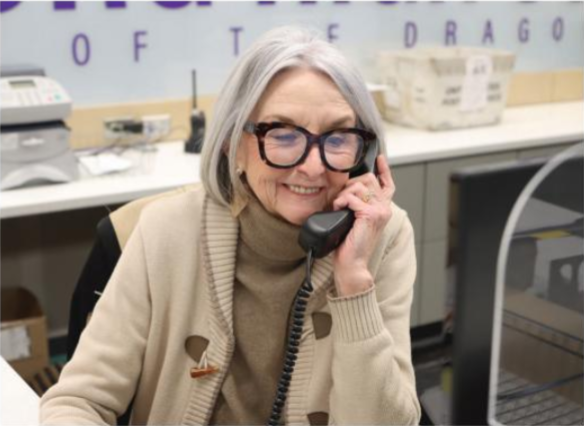 Secretary fill in Charlotte Barnett answers the phone as she reads from the computer.