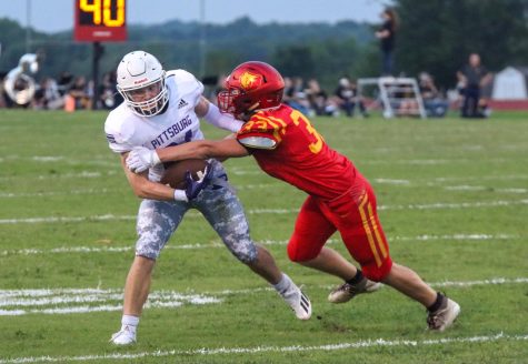 Passing off. Senior Grant Roelfs defends the ball against Labette Grizzlies, Sept. 4, at which the Dragons won, 28-0. I think of my job and how the defense is aligned and where the holes might be.” Roelfs said.