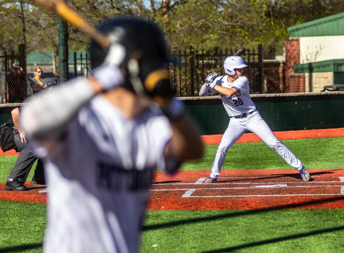 As junior Carsen Nickelson loads for the pitch, senior Grant ODoherty tries to get on time with the pitchers throwing speed in the on-deck circle. 