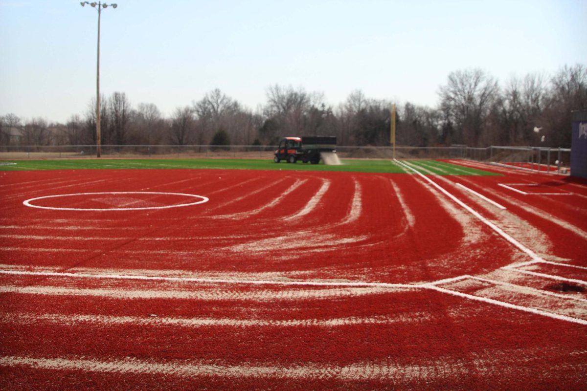 Mammoth pours sand over turf in process of finishing the field. 