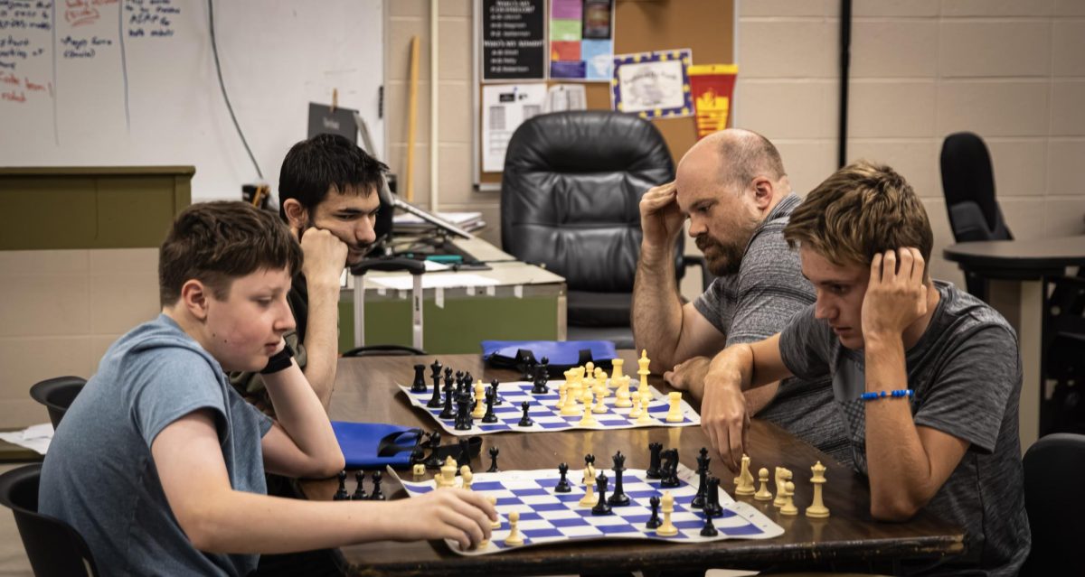 Chess matches, Junior Charles Anderson, Sophomore Ethan Pence, Sophomore Aiden Morrissette, and Robotics teacher Ryan Thies, gather around to play a match of chess against each other Oct. 10 Room 614.
