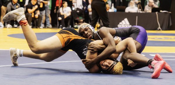 Fighting for control, Senior DeMarus Partee secures his hold on his opponent during an intense match up fighting for the win in the quarter finals at the Kansas State Wrestling Championship on Feb 27. “Since I wrestled him before, I knew the energy he gave out, giving me extra confidence to claim the win,” said Partee. “But I knew I needed to keep my focus on what needs to be done and making sure it is done correctly”.